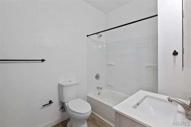 bathroom featuring toilet, wood finished floors, vanity, baseboards, and bathtub / shower combination
