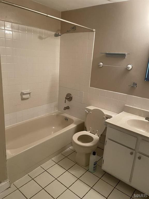 full bathroom featuring tile patterned floors, tile walls, toilet, bathing tub / shower combination, and vanity
