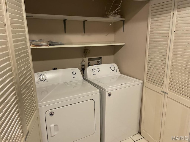 laundry room with independent washer and dryer and light tile patterned floors