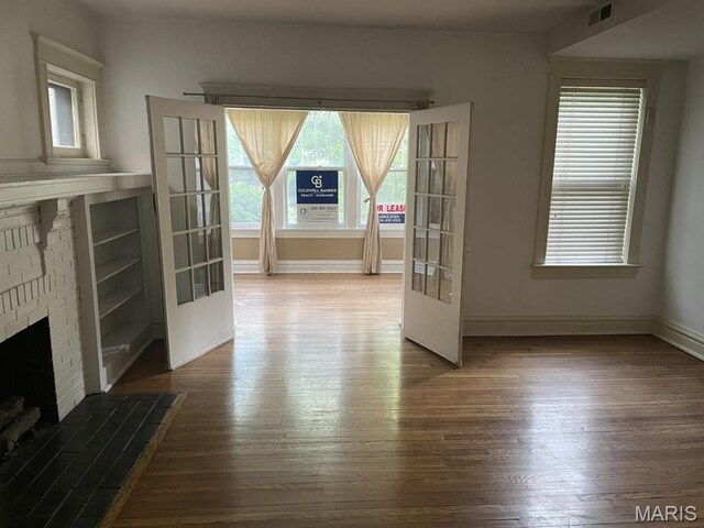 unfurnished living room featuring wood finished floors, a fireplace, and baseboards