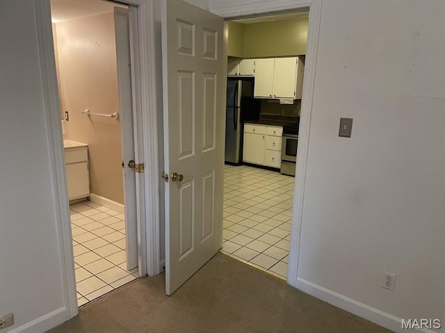 hall with light tile patterned flooring and baseboards