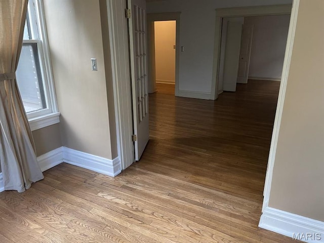 hall featuring baseboards and light wood-style floors