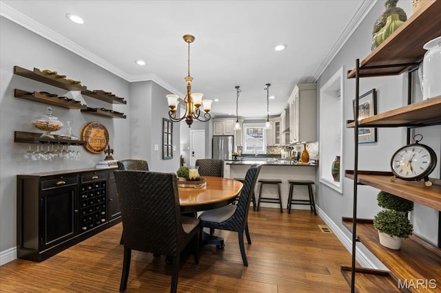 3884 Wyoming St, Saint Louis, MO 63116 - dining space featuring recessed lighting, crown molding, a chandelier, dark wood finished floors, and baseboards