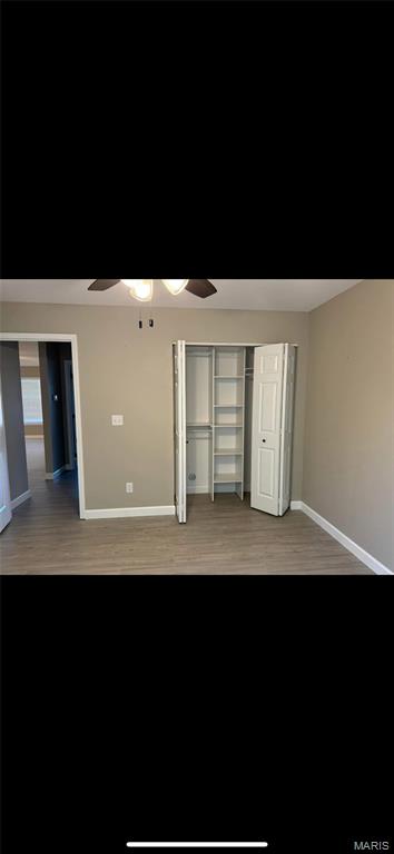 329 Rutledge St, Worden, IL 62097 - unfurnished bedroom with baseboards, wood finished floors, ceiling fan, and a closet