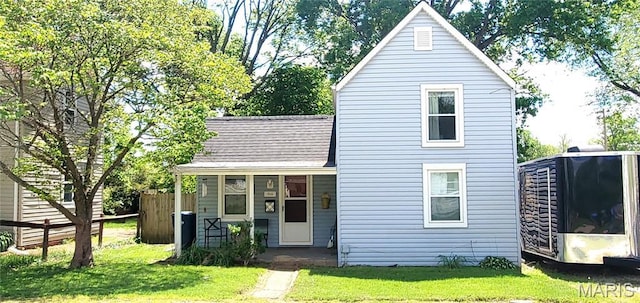 view of front of home featuring a front lawn and a shingled roof