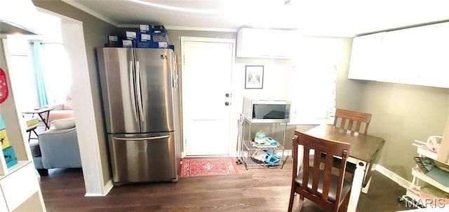kitchen featuring appliances with stainless steel finishes, ornamental molding, wood finished floors, and white cabinets