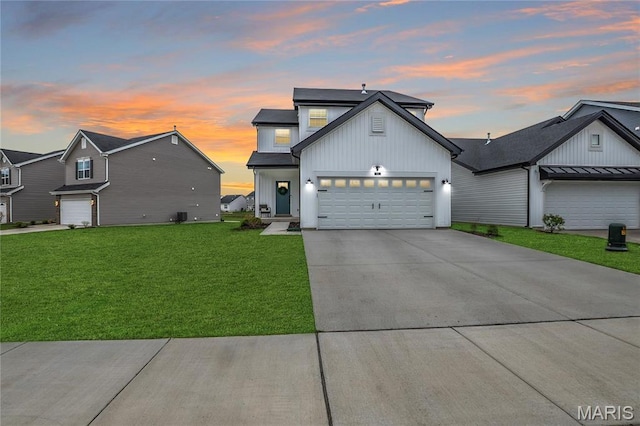 modern farmhouse style home featuring board and batten siding, a yard, driveway, and a garage