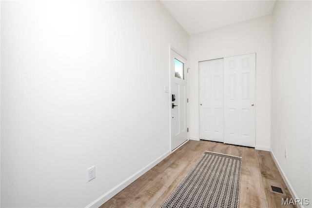 doorway featuring light wood-style flooring and baseboards