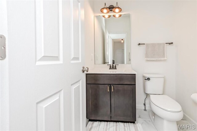 half bathroom with baseboards, marble look tile flooring, toilet, and vanity