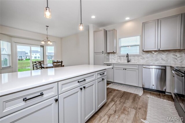 kitchen featuring dishwasher, a chandelier, light wood-type flooring, healthy amount of natural light, and recessed lighting