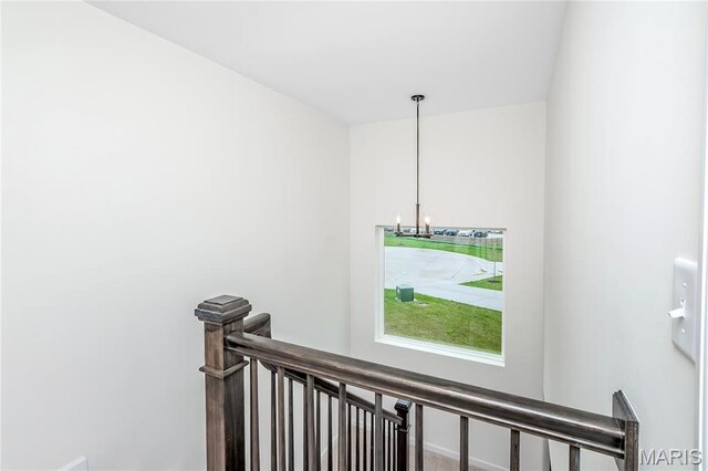 stairs featuring a chandelier and baseboards
