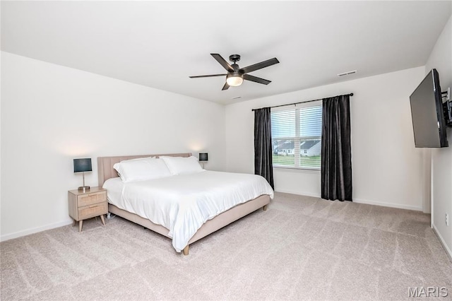 bedroom featuring light colored carpet, baseboards, and ceiling fan
