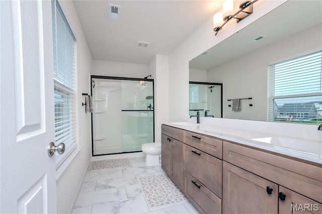 bathroom with marble finish floors, healthy amount of natural light, a stall shower, and toilet