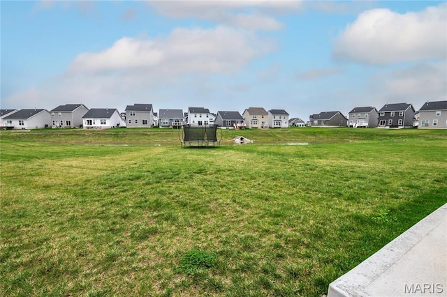 view of community with a trampoline, a residential view, and a yard
