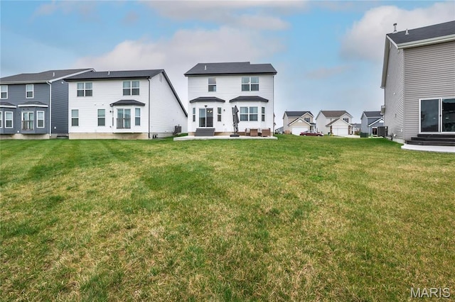 rear view of property with a residential view, a lawn, and central AC unit