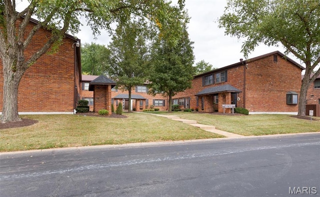view of front of house featuring brick siding and a front lawn