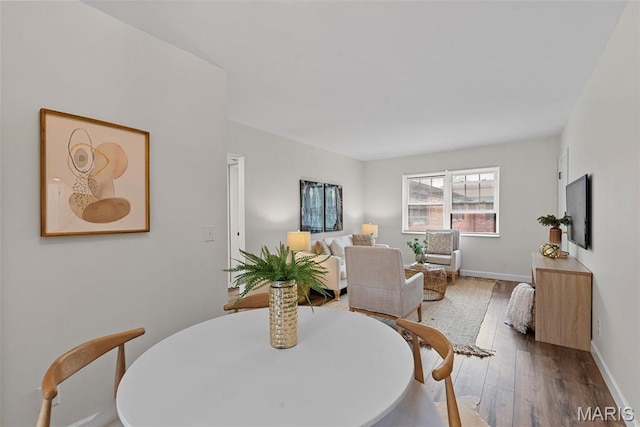 dining space with hardwood / wood-style flooring and baseboards