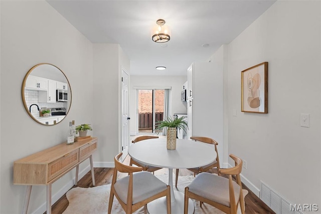 dining area with light wood-style flooring and baseboards