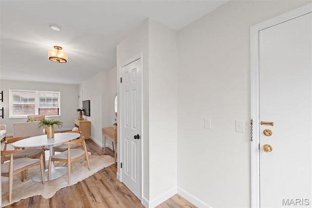 dining space with light wood-style flooring and baseboards