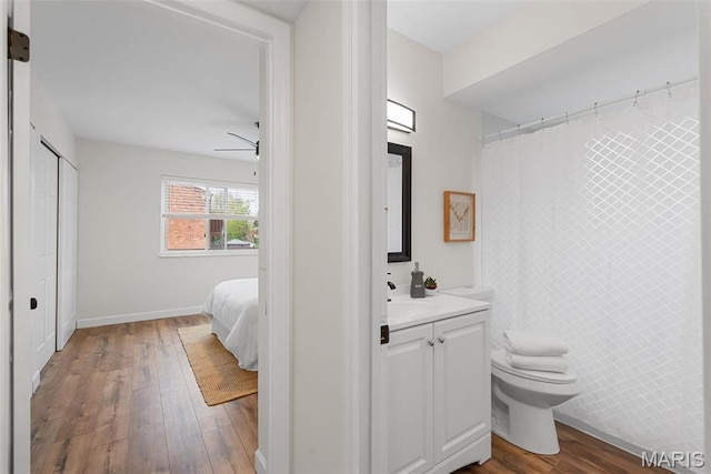 full bathroom featuring hardwood / wood-style floors, toilet, vanity, and baseboards