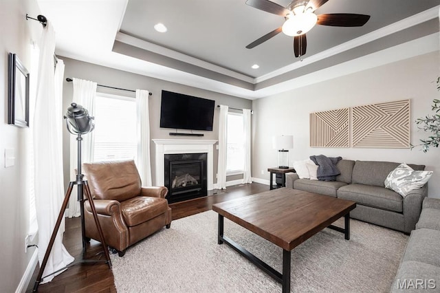 living room with dark wood finished floors, healthy amount of natural light, a ceiling fan, a high end fireplace, and recessed lighting