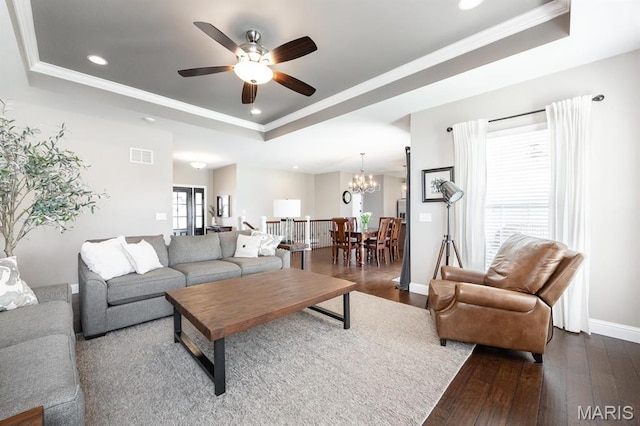 living room featuring a tray ceiling, dark wood finished floors, recessed lighting, ornamental molding, and a ceiling fan