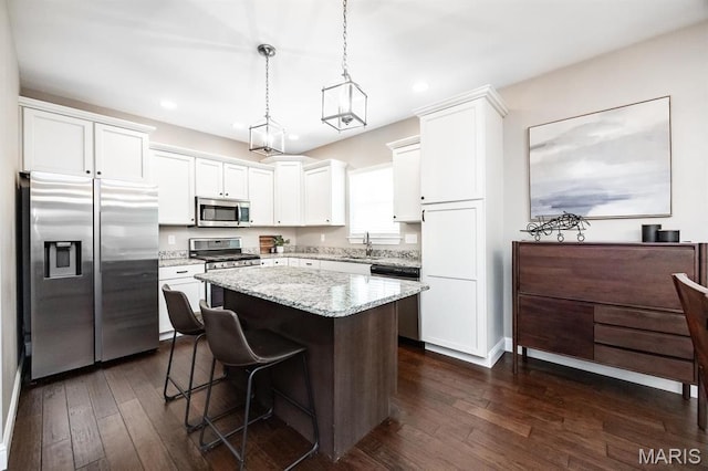 kitchen with stainless steel appliances, a sink, white cabinets, dark wood-style floors, and recessed lighting