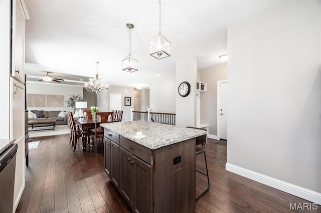 kitchen with a kitchen breakfast bar, dark brown cabinetry, dark wood-style floors, and pendant lighting