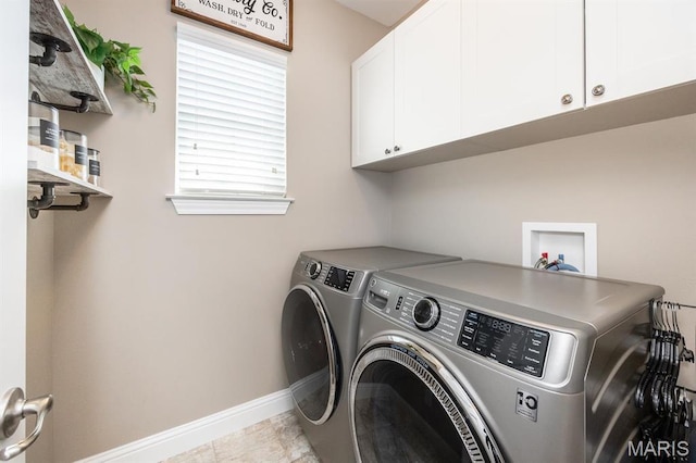washroom with washing machine and dryer, cabinet space, and baseboards