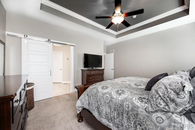 carpeted bedroom featuring a raised ceiling, a barn door, crown molding, and a ceiling fan