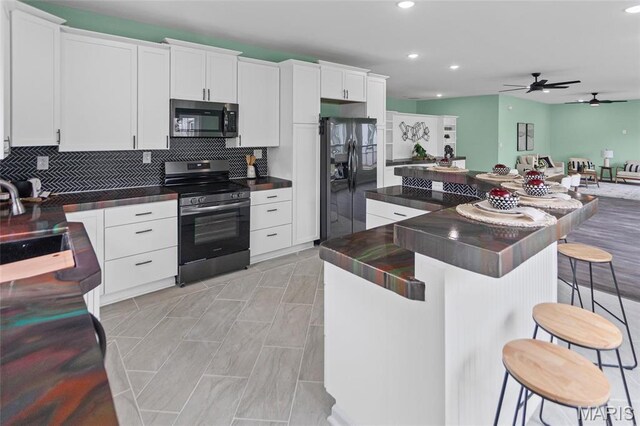 731 Dugger St, Bethalto, IL 62010 - kitchen with stainless steel range with electric cooktop, black refrigerator with ice dispenser, dark countertops, recessed lighting, and ceiling fan