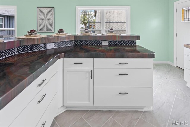 731 Dugger St, Bethalto, IL 62010 - kitchen featuring dark countertops, white cabinetry, and baseboards