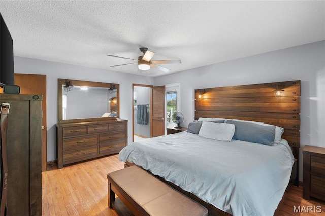 bedroom featuring light wood-style flooring, a ceiling fan, and a textured ceiling