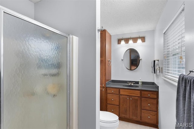 bathroom featuring a shower stall, a textured ceiling, vanity, and toilet