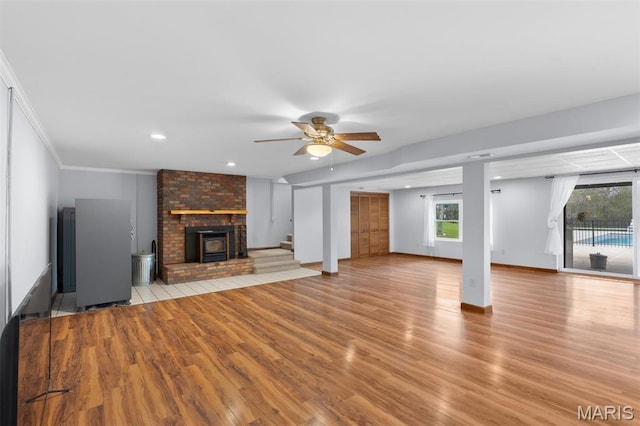 unfurnished living room with wood finished floors, ceiling fan, stairs, recessed lighting, and baseboards