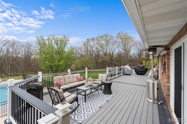 wooden terrace featuring an outdoor hangout area and view of wooded area