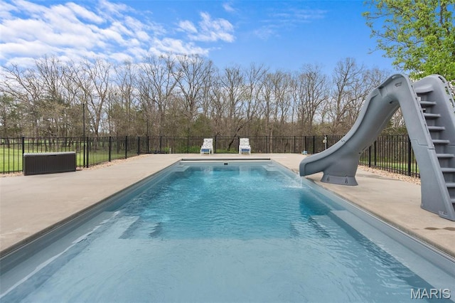 view of pool with a water slide, fence, and a patio area