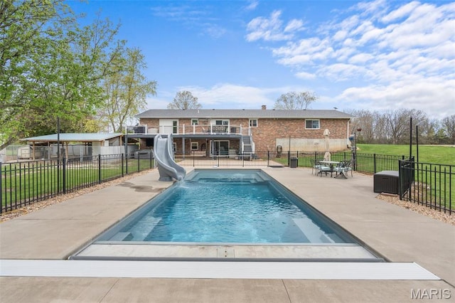 view of swimming pool featuring a water slide, stairs, a patio, and a wooden deck
