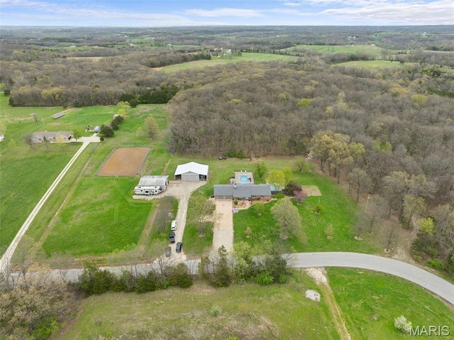 aerial view of property's location featuring rural landscape and a forest