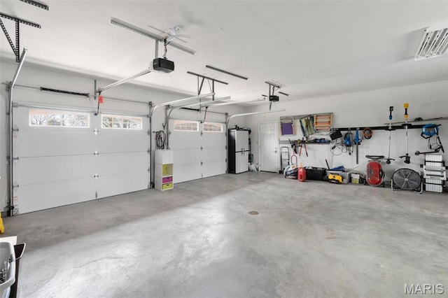 garage with a garage door opener and freestanding refrigerator