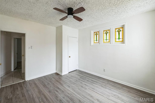 4931 Mardel Ave, Saint Louis, MO 63109 - unfurnished bedroom with wood finished floors, a textured ceiling, baseboards, ceiling fan, and a closet