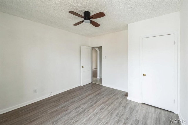 4931 Mardel Ave, Saint Louis, MO 63109 - unfurnished bedroom featuring wood finished floors, a textured ceiling, baseboards, and a ceiling fan