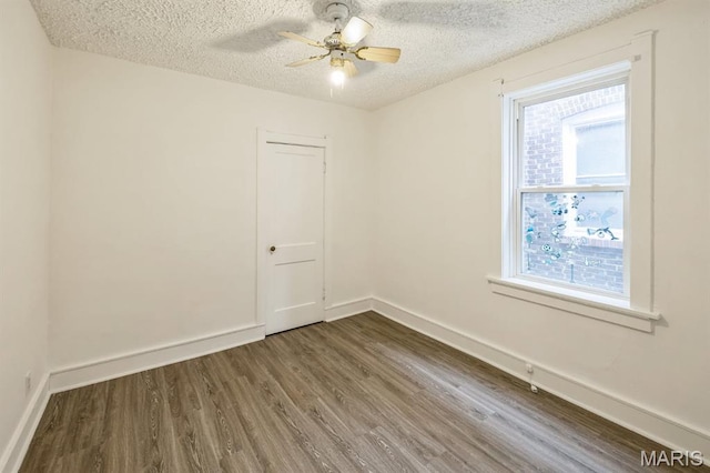 4931 Mardel Ave, Saint Louis, MO 63109 - spare room with a textured ceiling, dark wood-type flooring, healthy amount of natural light, ceiling fan, and baseboards