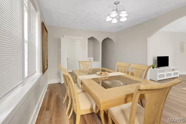 4931 Mardel Ave, Saint Louis, MO 63109 - dining room featuring arched walkways, a chandelier, and wood finished floors