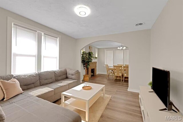 4931 Mardel Ave, Saint Louis, MO 63109 - living room featuring arched walkways, light wood-style flooring, and baseboards