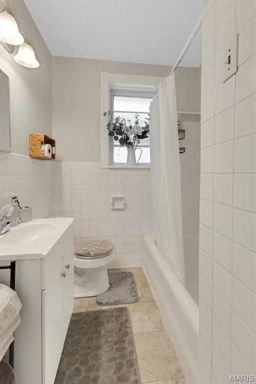 4931 Mardel Ave, Saint Louis, MO 63109 - full bathroom featuring tile walls, vanity, toilet, and shower / bath combo