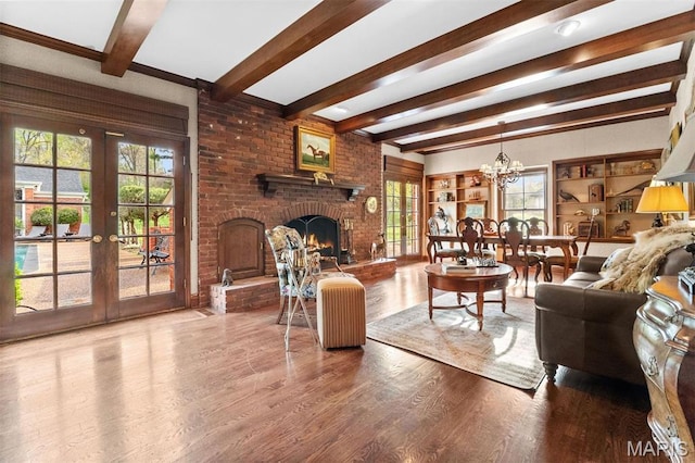 21 Log Cabin Dr, Saint Louis, MO 63124 - living area with french doors, beam ceiling, healthy amount of natural light, a brick fireplace, and wood finished floors