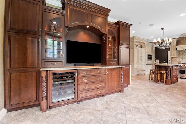 21 Log Cabin Dr, Saint Louis, MO 63124 - bar featuring beverage cooler, a chandelier, high end stove, tasteful backsplash, and recessed lighting