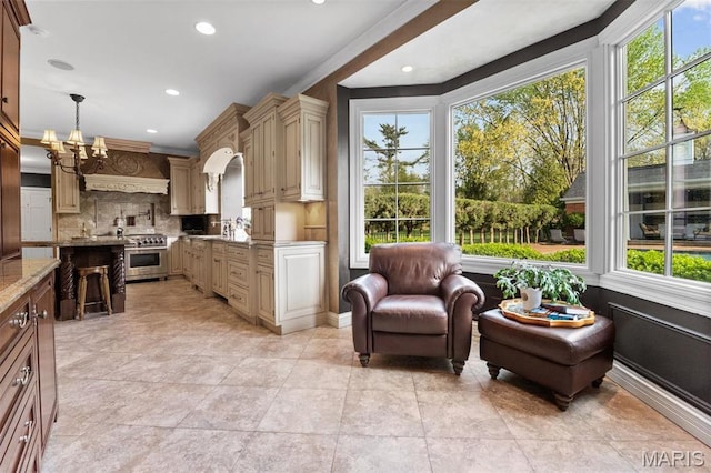 21 Log Cabin Dr, Saint Louis, MO 63124 - kitchen featuring a chandelier, healthy amount of natural light, stainless steel range, tasteful backsplash, and ornamental molding