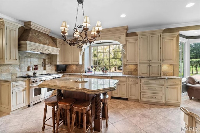 21 Log Cabin Dr, Saint Louis, MO 63124 - kitchen featuring cream cabinetry, range with two ovens, premium range hood, backsplash, and recessed lighting